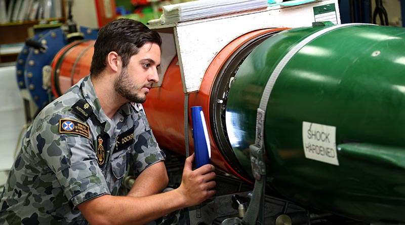 Able Seaman Matthew Dockrill conducts a routine inspection between the after body and fuel cell of a MK48 Heavy Weight Torpedo in the Torpedo Maintenance Facility at the Navy Guided Weapons Systems Program Office-West on HMAS Stirling. Photo by Chief Petty Officer Damian Pawlenko.