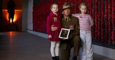 Army soldier Sergeant Jonathan Apps, of Australia's Federation Guard, with his daughters and a picture of his great-grandfather at the Australian War Memorial, Canberra, during preparations for Anzac Day 2025. Story. y Captain Katy Manning. Photo by Leading Seaman Kylie Jagiello.