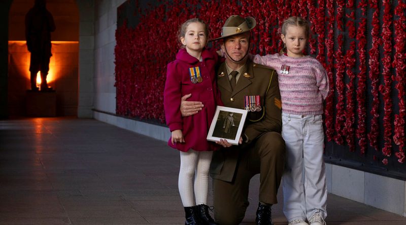 Army soldier Sergeant Jonathan Apps, of Australia's Federation Guard, with his daughters and a picture of his great-grandfather at the Australian War Memorial, Canberra, during preparations for Anzac Day 2025. Story. y Captain Katy Manning. Photo by Leading Seaman Kylie Jagiello.