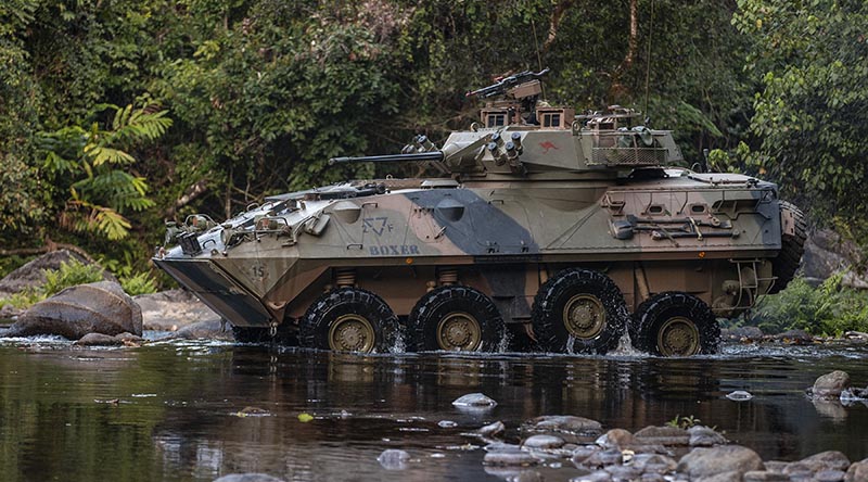 An Australian light-armoured vehicle (ASLAV) negotiates a creek crossing during an exercise at Jungle Training Wing, Tully, Queensland. Photo by Corporal Nicole Dorrett.