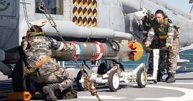 Royal Australian Navy Flight 607 personnel transfer a training torpedo onto an MH-60R Seahawk on the flight deck of HMAS Hobart. Photo by Leading Seaman Iggy Roberts.