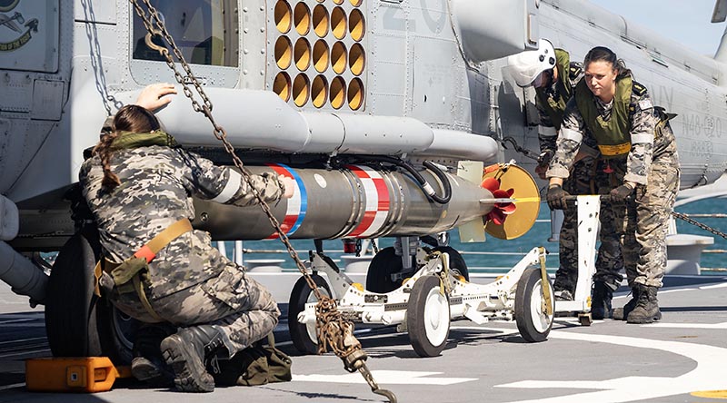 Royal Australian Navy Flight 607 personnel transfer a training torpedo onto an MH-60R Seahawk on the flight deck of HMAS Hobart. Photo by Leading Seaman Iggy Roberts.