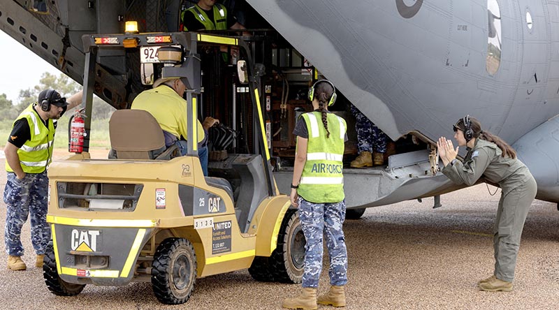 Royal Australian Air Force aviators assist local man Brian Dayes unload fuel stores from a C-27J Spartan in Windorah, Queensland. Photo by Aircraftwoman Nell Bradbury.