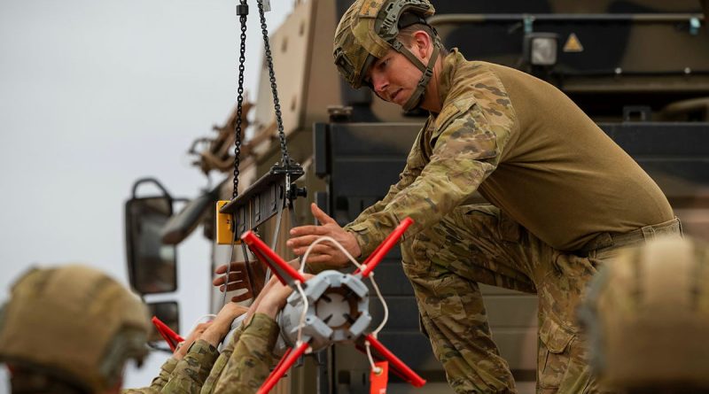 Australian Army soldier Gunner Thomas Hayes, from 111 Battery, 16th Regiment, Royal Australian Artillery, helps load a Sidewinder missile on a NASAMS High-Mobility Launcher during a live-fire certification activity at Woomera Test Range, South Australia. Story and photos by Corporal Jacob Joseph.