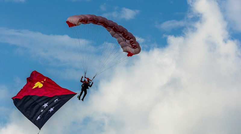 An Australian Army member from the Parachute Training School descend into Sir Hubert Murray Stadium from a PNG Defence Force aircraft during the Military Tattoo at Port Moresby. Story by Captain Katy Manning. Photos by Corporal Jack Pearce.