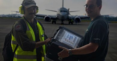 Royal Australian Air Force Flying Officer Eric Morant and Leading Aircraftman Lachlan McAndrew exchange mission data from the P-8A during Operation Argos at Kadena Air Base, Japan. Story and photos by Corporal Luke Bellman.