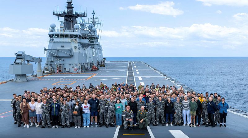 HMAS Canberra crew are joined by families and guests on the flight deck for a whole ship photo off the NSW coast. Story by Lieutenant Hinako Shiraishi. Photos by Able Seaman Taylor Johnson.