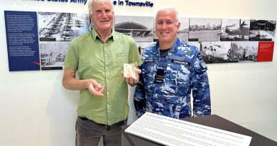 Clive Wawn Junior holding the ‘short snorter’ with Squadron Leader Andrew Chadwick at the RAAF Townsville Aviation Heritage Centre. Story and photos by Flying Officer Casie Scott.