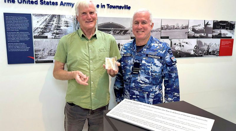 Clive Wawn Junior holding the ‘short snorter’ with Squadron Leader Andrew Chadwick at the RAAF Townsville Aviation Heritage Centre. Story and photos by Flying Officer Casie Scott.