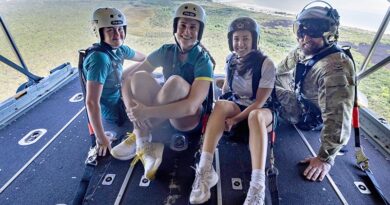 Australian Olympians Haylie Powell and Natalya Diehm, Australian Olympic Committee member Melissa Romer, and Senior Indigenous Liaison Officer, Squadron Leader Coen Henry, sit on the ramp of a Royal Australian Air Force C-130J Hercules during Exercise Christmas Hop 2025, over the Northern Territory. Photo by Leading Aircraftman Campbell Latch.